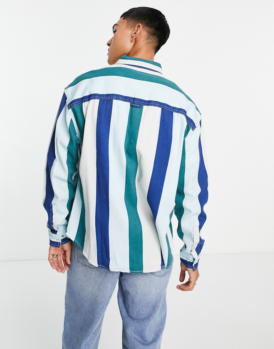 Meska-niebieska-koszula-oversize-z-diagonalu-w-uczelniane-paski-z-haftem-pilki-do-koszykowki-w-stylu-lat-90-XL-1 Meska-niebieska-koszula-oversize-z-diagonalu-w-uczelniane-paski-z-haftem-pilki-do-koszykowki-w-stylu-lat-90-XL